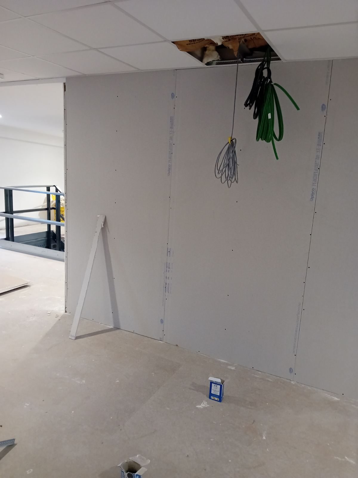 Cloison en plaques de plâtre posée sous un faux plafond
